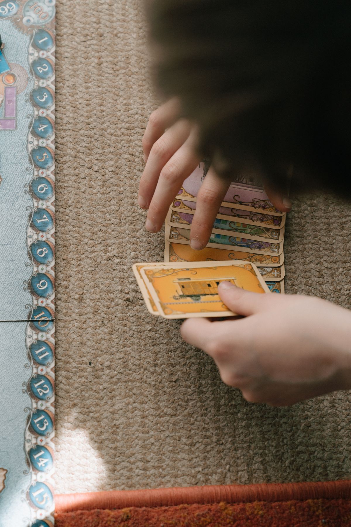 Hands playing a board game during family game night at home
