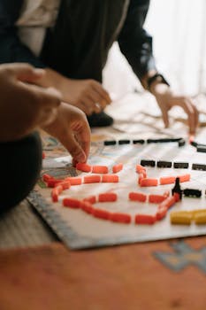 Players engage in a strategic board game, enhancing focus and teamwork indoors.