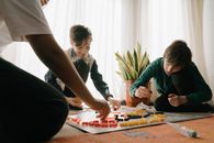 三个孩子在室内玩战略棋盘游戏，既有趣又能促进团队合作