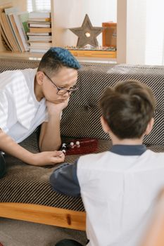 两个男孩正专注地在室内玩着战略棋盘游戏，享受休闲时光