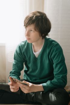 一个小男孩在室内专注地玩着战略纸牌游戏