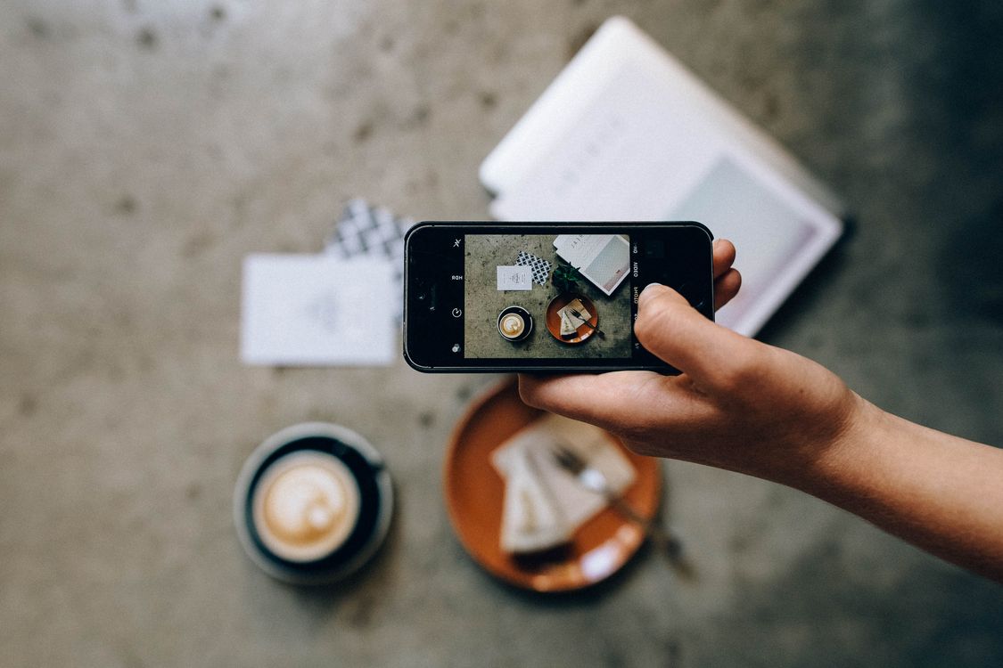 hand holding phone coffee cake photo
