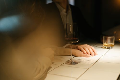 Free Intimate moment at a bar counter with a couple enjoying wine and atmosphere. Stock Photo