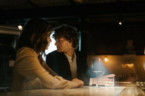 Woman in White Blazer Sitting Beside Woman in White Long Sleeve Shirt