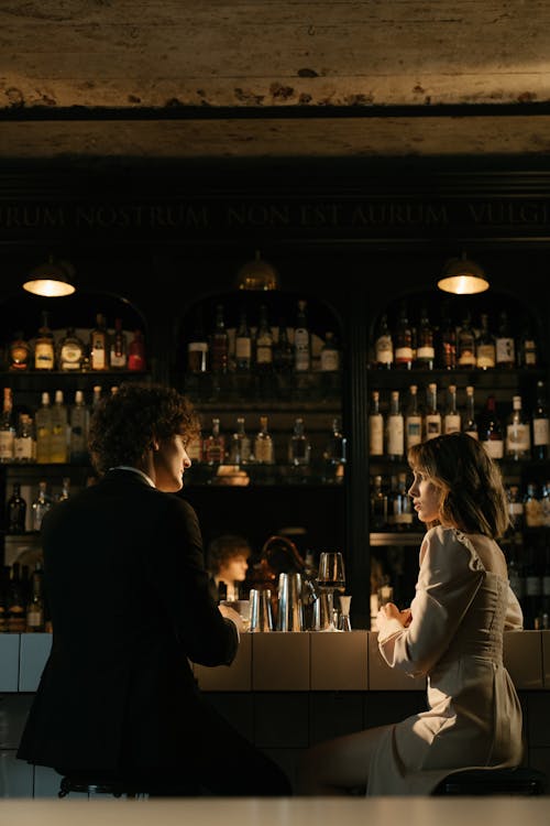 Man in Black Suit Jacket Standing Beside Woman in White Long Sleeve Shirt