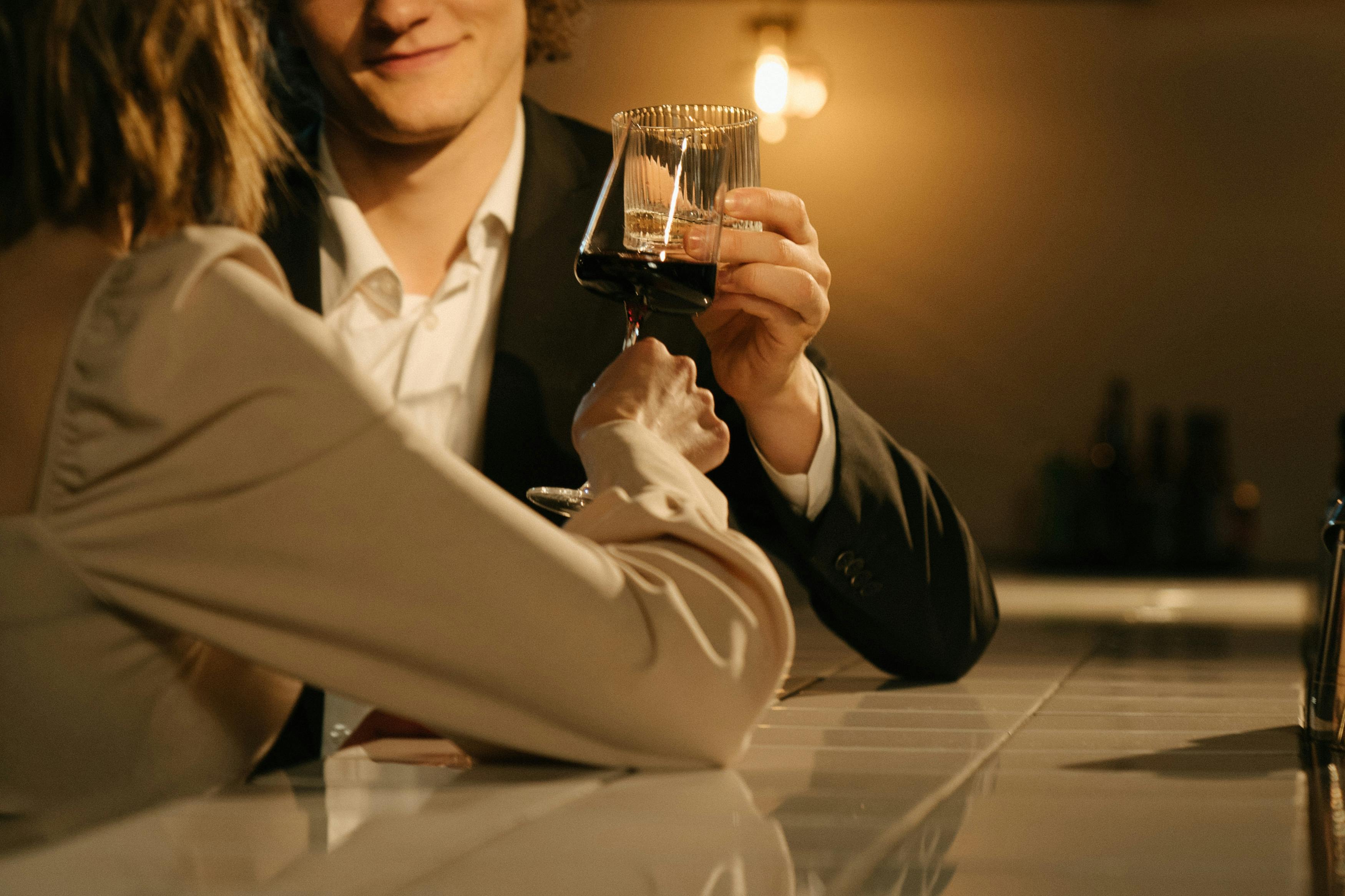 woman in white blazer holding clear drinking glass