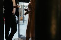 一对时尚的夫妇在酒吧入口处喝着饮品，氛围亲密而优雅