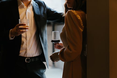 Woman in White Dress Shirt and Black Blazer Holding Clear Drinking Glass