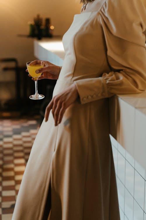 Free Woman in Brown Coat Holding Clear Wine Glass Stock Photo