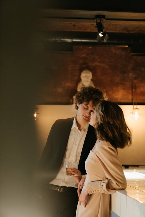 Man in White Suit Kissing Woman in White Coat