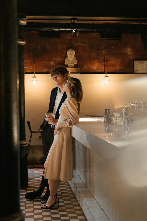 Woman in Beige Coat Standing Beside Mirror