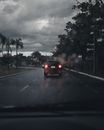 阴沉的城市场景下，汽车在多云的雨天道路上行驶，捕捉了城市交通的本质