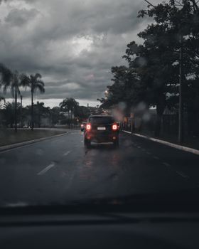 阴沉的城市场景下，汽车在多云的雨天道路上行驶，捕捉了城市交通的本质