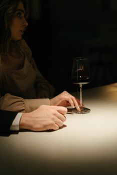 一对男女在昏暗的酒吧里优雅而亲密地品着葡萄酒