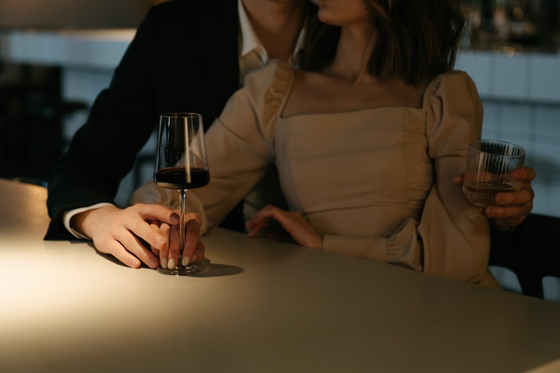 Free Woman in Beige Long Sleeve Shirt Holding Wine Glass Stock Photo