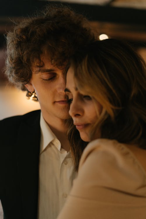 Man in Black Suit Kissing Woman in White Dress Shirt