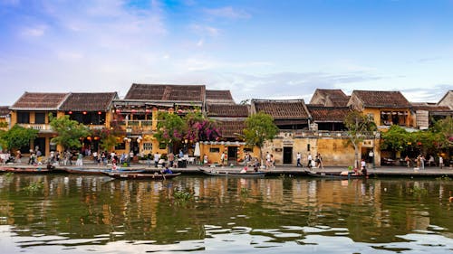 Boats Docked on Canal Near an Old Town