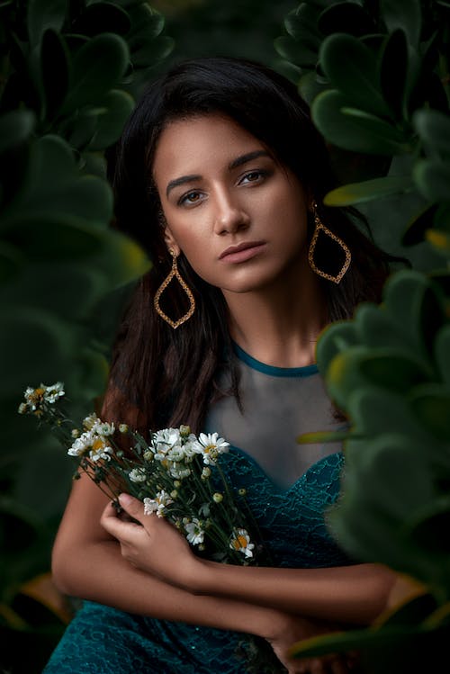 Portrait of a Young Woman with an Armful of Chamomile Sitting Among the Leaves