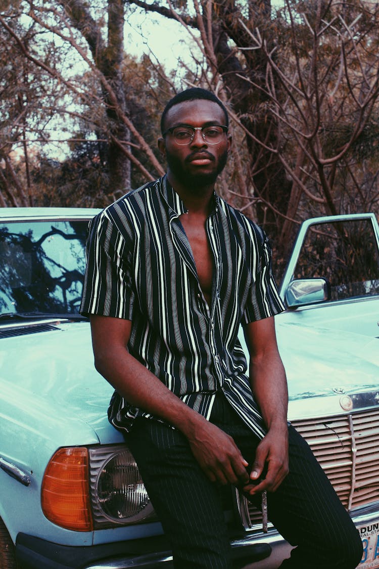 Stylish Black Man Sitting On Retro Car