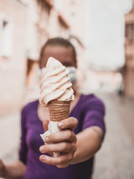 A person holding a soft-serve ice cream cone outdoors, creating a delightful summer vibe.
