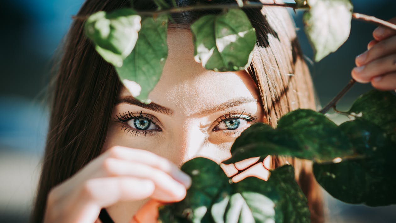 A Woman Covering Her Face With Green Leaves · Free Stock Photo