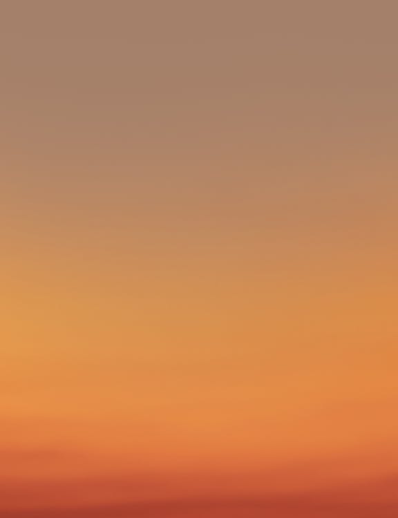 Picturesque view of abstract clear sundown sky background gradient from light yellow to bright orange at evening time in nature