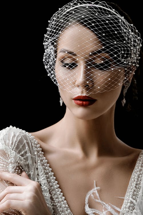 Elegant young woman in white net veil