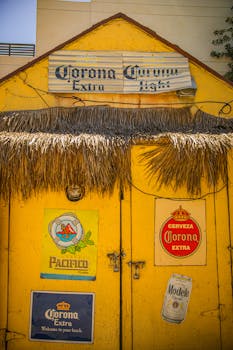 A vibrant yellow entrance adorned with vintage beer signage in a rustic setting.