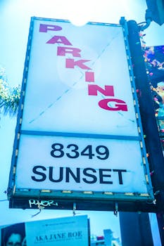 Bright parking sign at 8349 Sunset Boulevard, Los Angeles, illuminated in daylight.