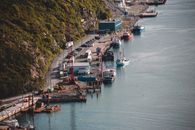 From above of motorized launch boats on green bushy rocky coast near water