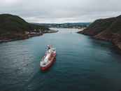 Modern equipped boat sailing between cliffs