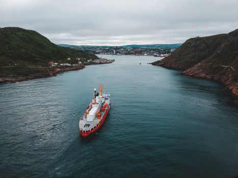 Modern equipped boat sailing between cliffs