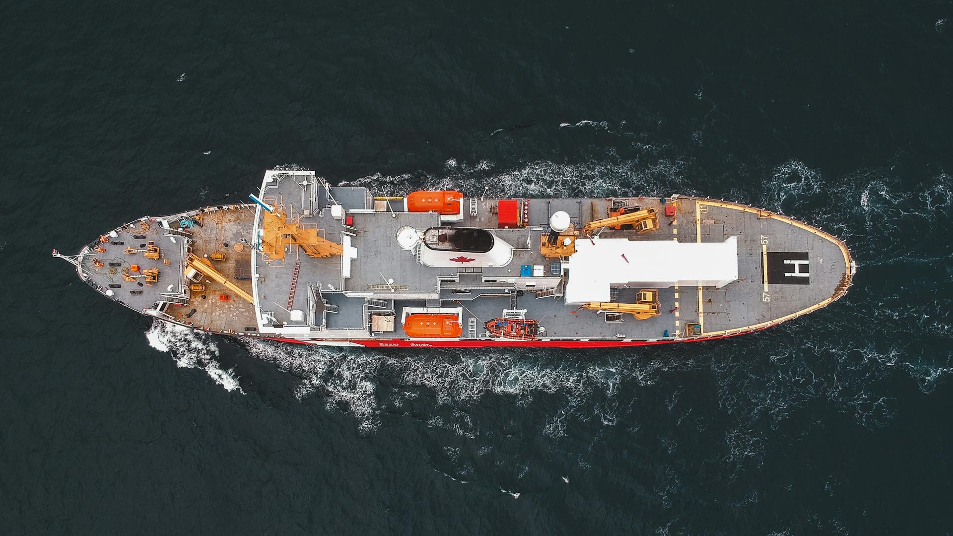 A stunning aerial view of a cargo ship navigating through the open sea, showcasing marine transportation.