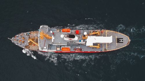 Free A stunning aerial view of a cargo ship navigating through the open sea, showcasing marine transportation. Stock Photo