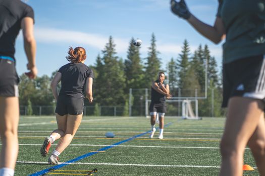 Women athletes training on a sunny day in Ottawa, focusing on teamwork and fitness.