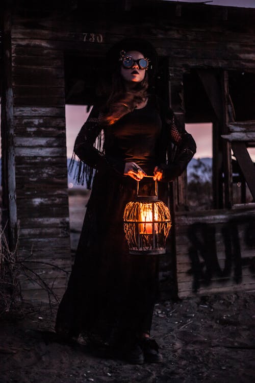 бесплатная Женщина в черном платье с длинным рукавом стоит на сером бетонном полу Стоковое фото