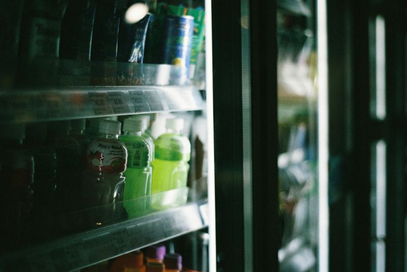 Close-up view of assorted drinks inside a refrigerated store display case