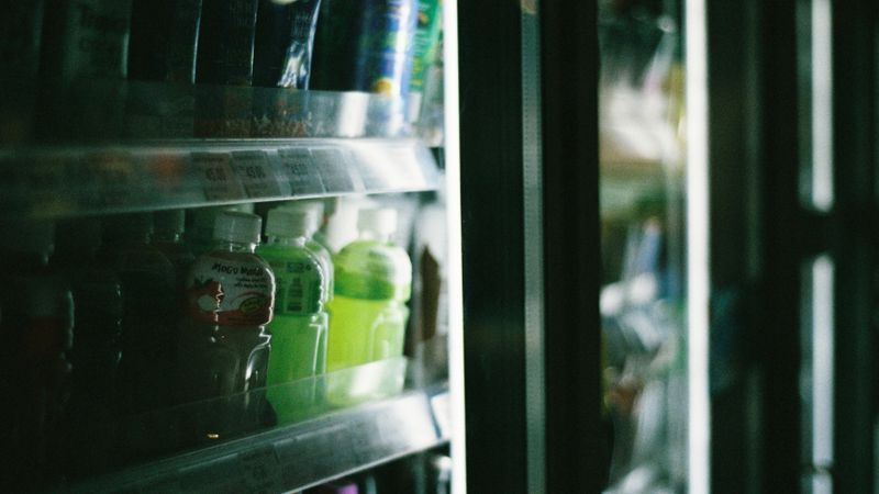 open refrigerator with shelves of groceries neatly spaced and a clear gap at the back wall