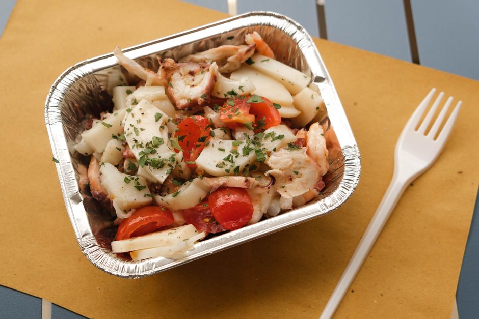 Ensalada de calamar fresco en cuenco, con trozos de calamar blanco y transparente sobre lecho de verduras