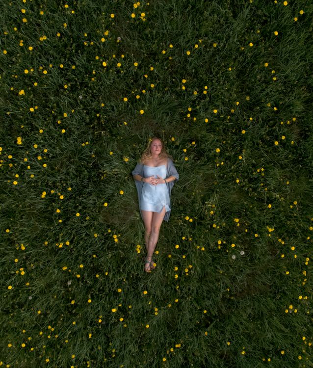Woman in Blue Dress Lying on a Yellow Flower Field · Free Stock Photo