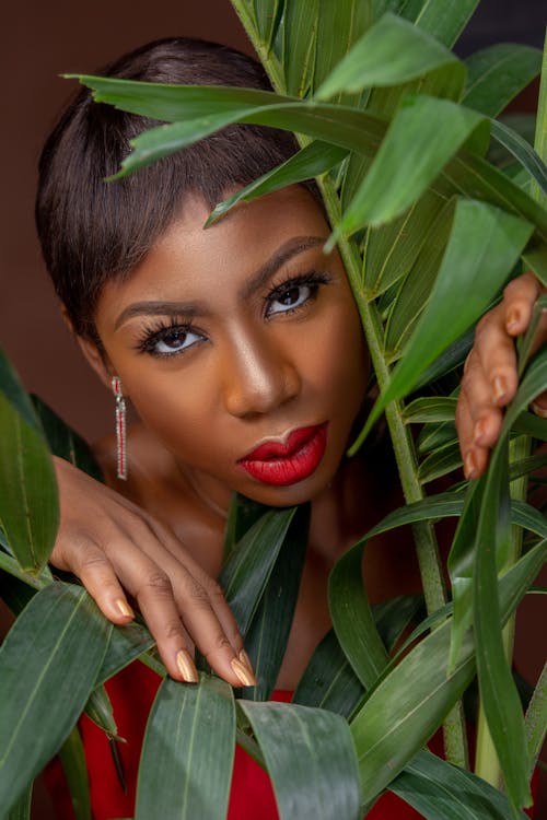 A Woman with Red Lipstick Posing with Leaves