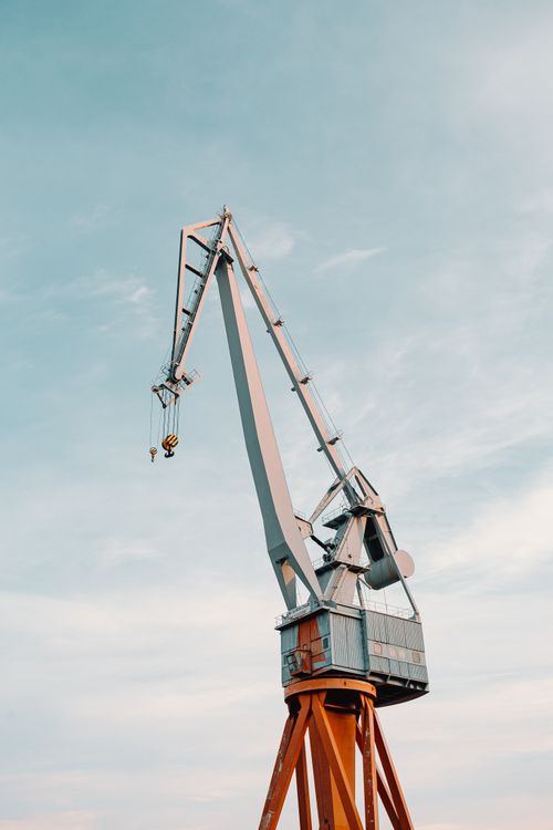 Free From below of modern metal crane building new skyscraper under clear blue sky on daytime Stock Photo