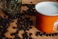 Cup of coffee with beans on table
