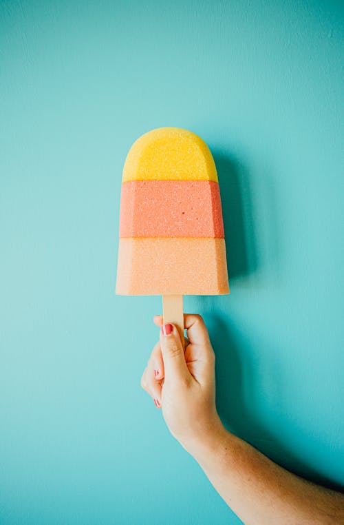 Bright multicolored ice cream in hand