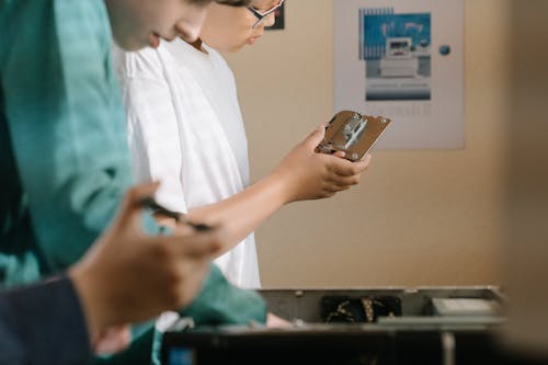 Man in White Shirt Holding Silver Iphone 6