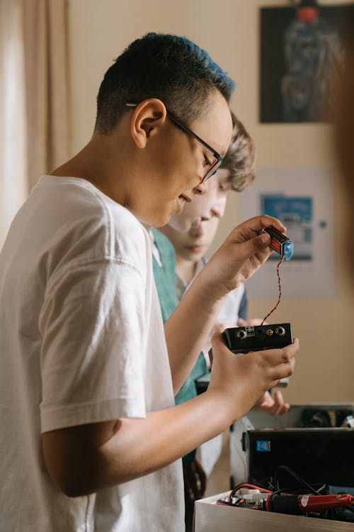 Man in White T-shirt Holding Black Smartphone