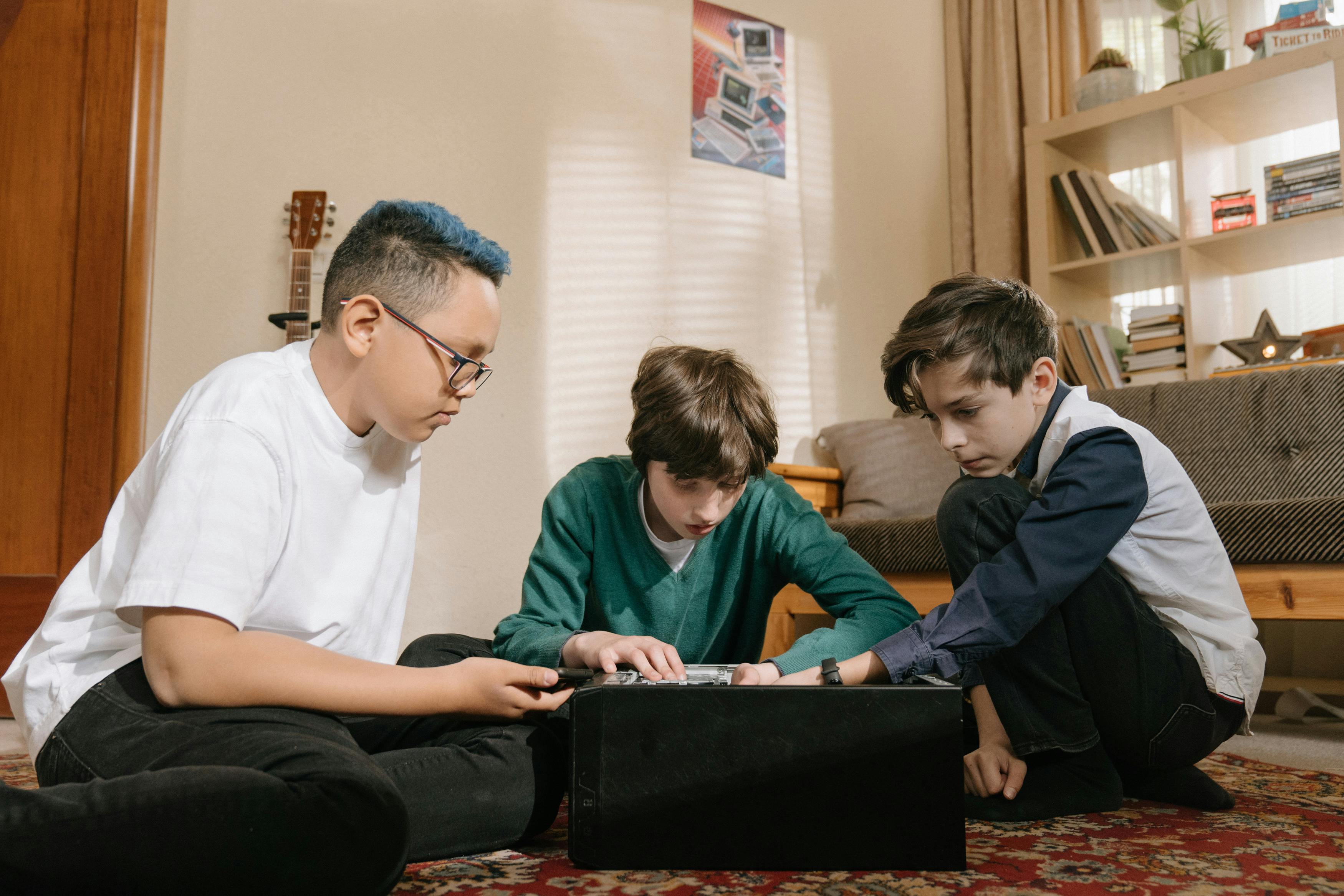 Close-up of a disassembled laptop motherboard and components on a white desk