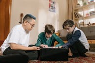 三个孩子在家通过探索电子产品，培养好奇心和团队合作精神