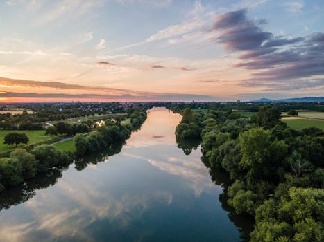 A tranquil aerial view of a river reflecting the sunset in Edingen-Neckarhausen, Germany.