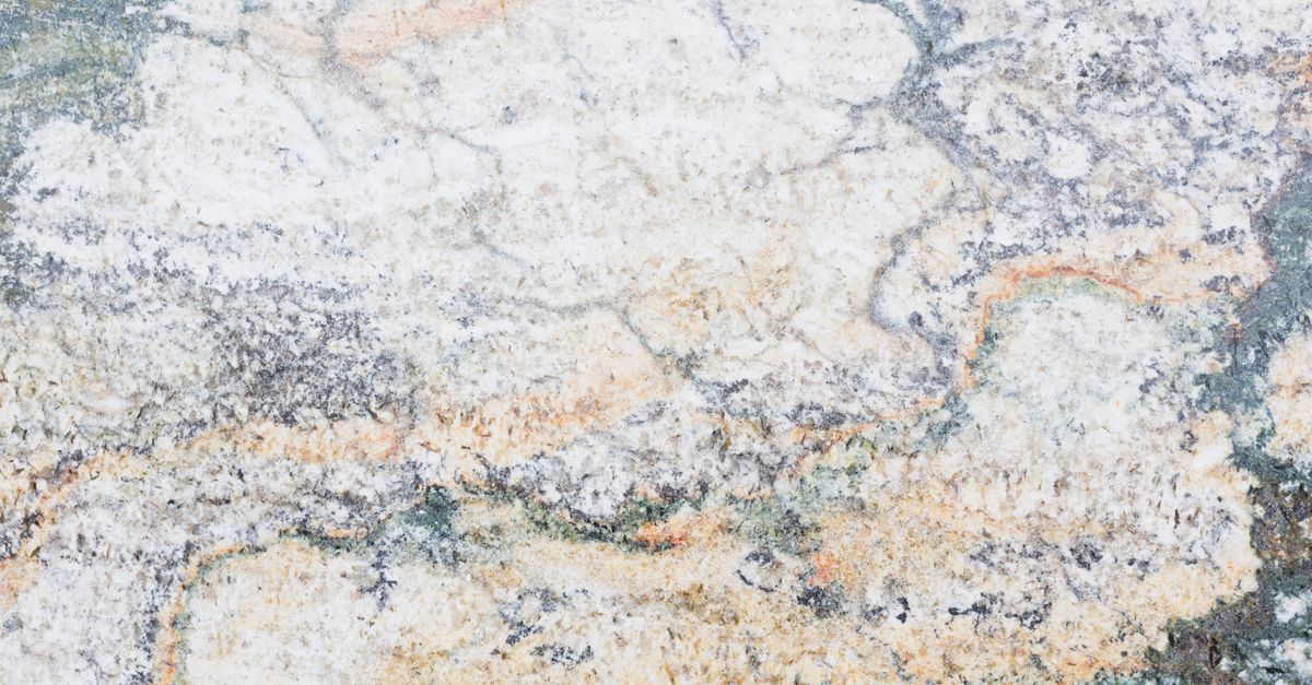 Close-up of textured marble surface showcasing unique patterns and earthy tones, ideal for design backgrounds.
